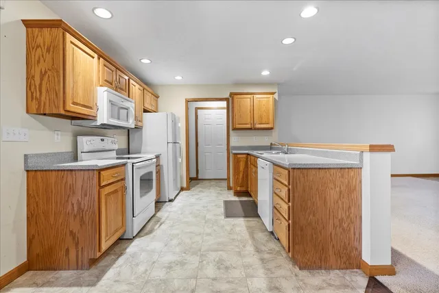 a kitchen with stainless steel appliances granite countertop a stove a sink and a refrigerator