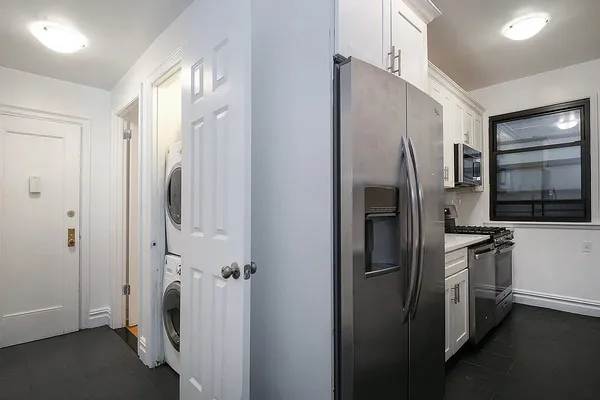 a view of a refrigerator in kitchen and a sink