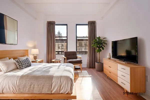 a bedroom with a flat screen television and a bed