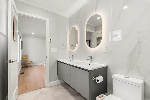 a bathroom with a toilet sink and mirror