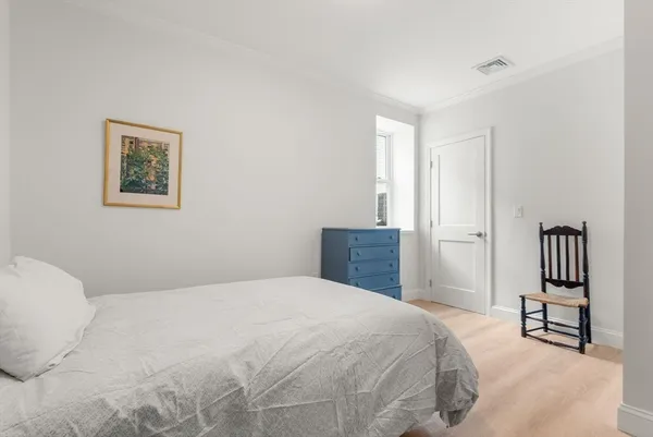a bedroom with a large bed and a chandelier