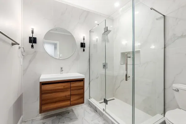 a bathroom with a sink a toilet and shower