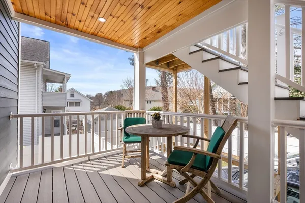 a view of a balcony with furniture and wooden floor
