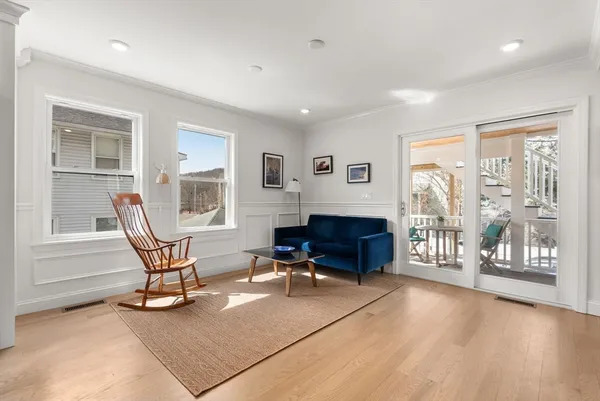 a living room with furniture a flat screen tv and windows