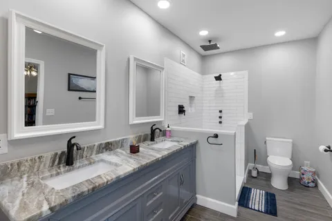 a bathroom with a granite countertop sink and a mirror