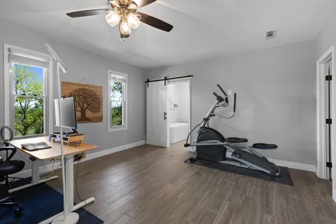 a room with gym equipment and wooden floor