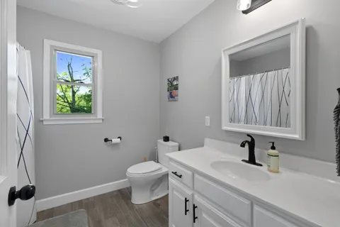 a bathroom with a sink a toilet and a window