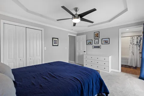 a bedroom with a large bed and a chandelier