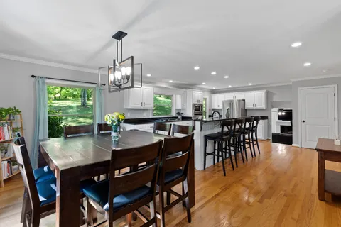 a dining room with furniture window and wooden floor