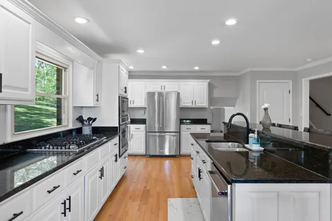 a kitchen with stainless steel appliances granite countertop a sink stove and refrigerator