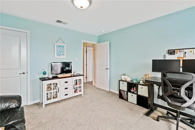 a view of a workspace with furniture and a flat screen tv