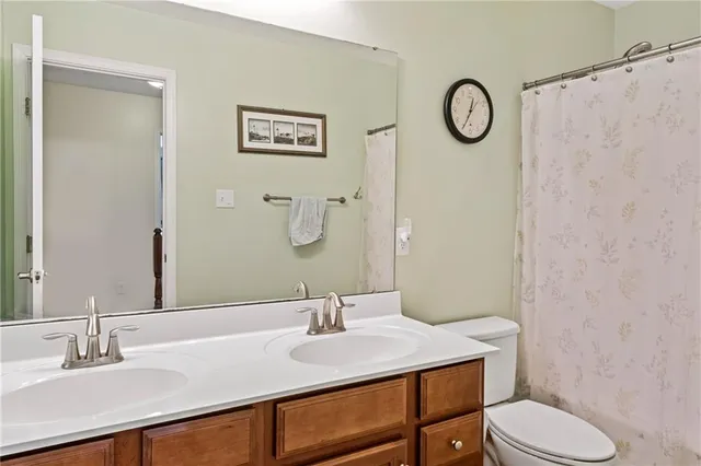 a bathroom with a sink vanity mirror and toilet