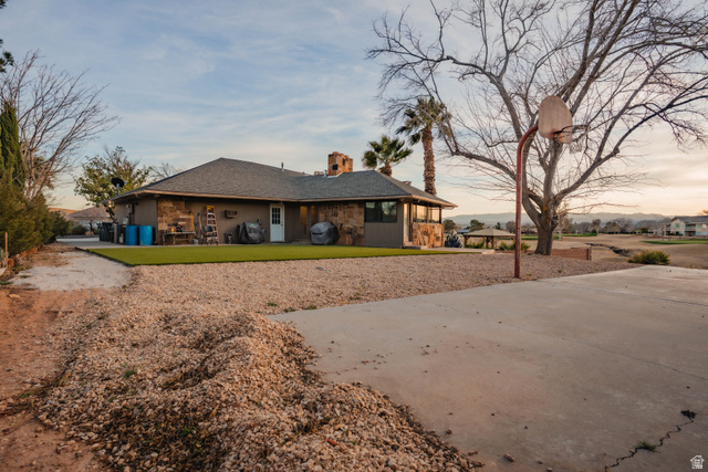 980 Cactus Circle St. George, UT 84790 - Photo 53 of 77 View of front of house featuring a chimney, roof with shingles, a front yard, and a patio area