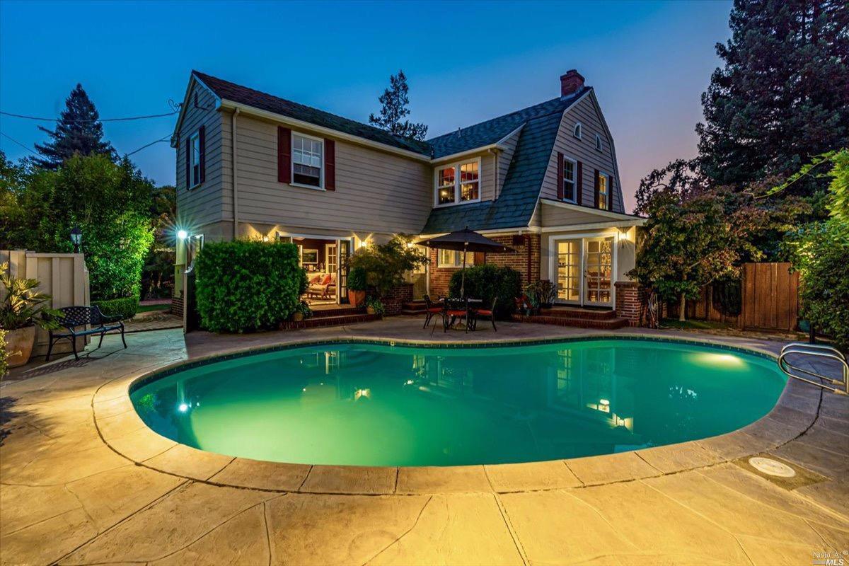 a view of a house with swimming pool and sitting area