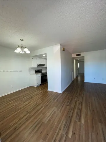 a view of a kitchen with wooden floor and a kitchen