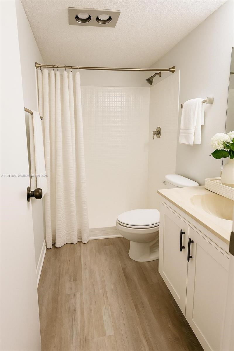 227 Castlewood Drive, Unit 102 North Palm Beach, FL 33408 - Photo 20 of 26 a bathroom with a granite countertop sink a toilet and a shower