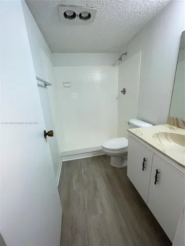 a bathroom with a granite countertop sink toilet and shower