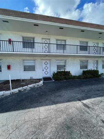a room with lots of white furniture and a window