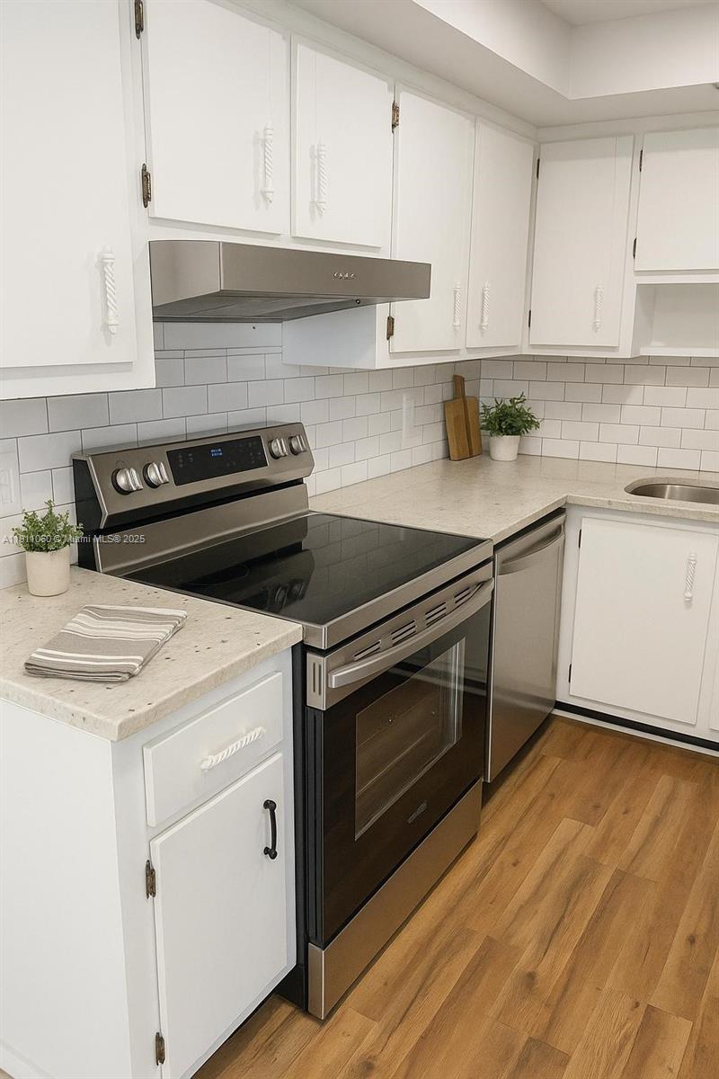 227 Castlewood Drive, Unit 102 North Palm Beach, FL 33408 - Photo 7 of 26 a kitchen with granite countertop white cabinets and white appliances