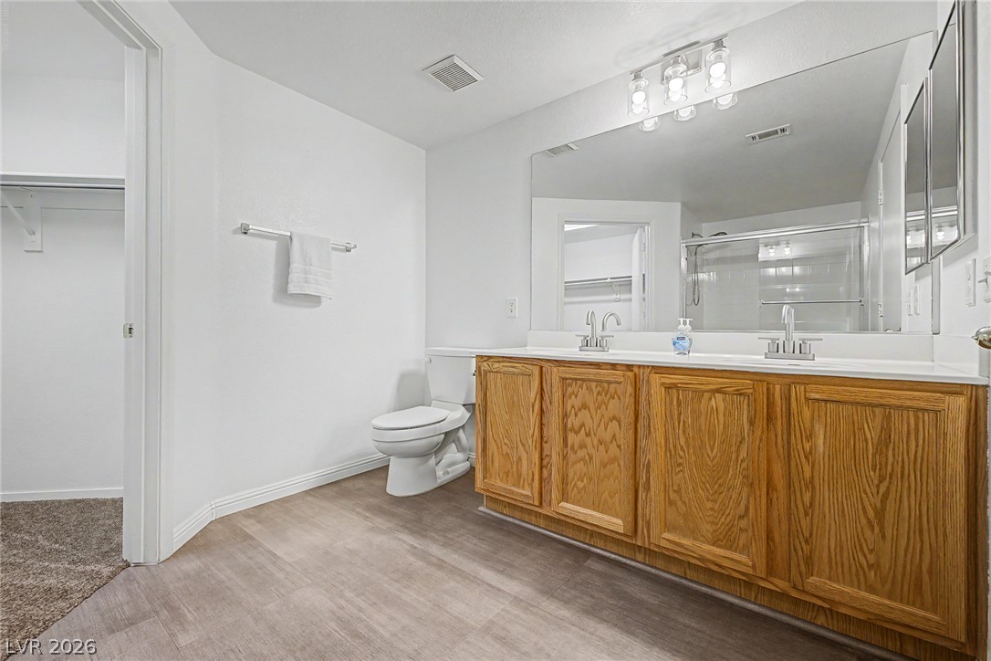 2153 Quarry Ridge Street, Unit 103 Las Vegas, NV 89117 - Photo 23 of 42 A pristine bathroom featuring a double vanity with ample storage and a clear shower enclosure.