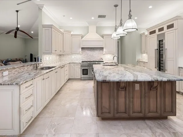 a kitchen with granite countertop a stove a sink a refrigerator and a wooden cabinets