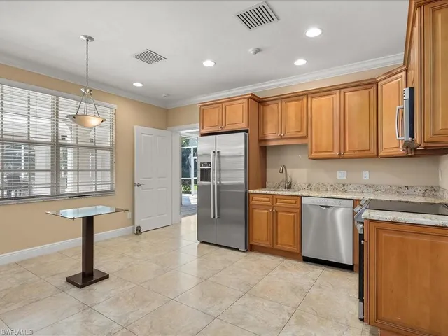 a kitchen with stainless steel appliances granite countertop a refrigerator a sink a stove and cabinets