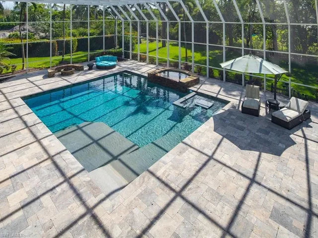 a view of a swimming pool with chairs in patio