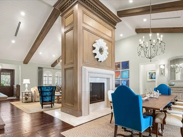 a living room with furniture a chandelier and a fireplace