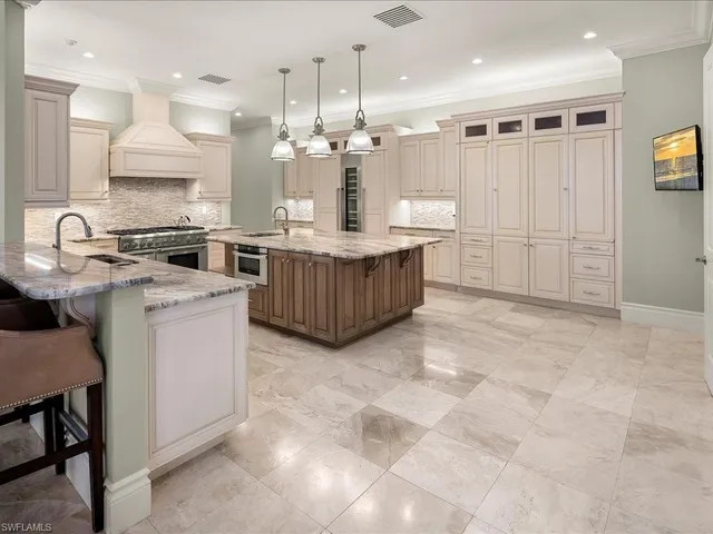 a kitchen with kitchen island granite countertop a sink counter top space appliances and cabinets
