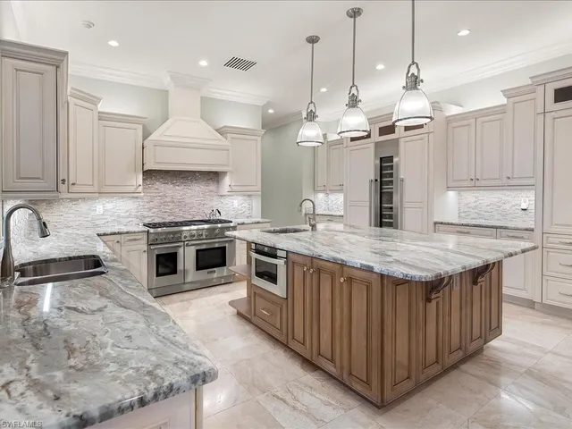 a kitchen with stainless steel appliances granite countertop a stove a sink and a refrigerator