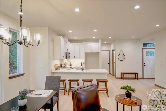 a living room with furniture a mirror and wooden floor