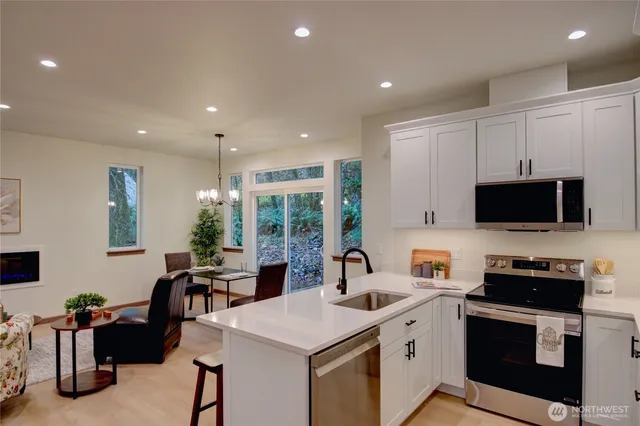 a kitchen with stainless steel appliances granite countertop a refrigerator sink and stove