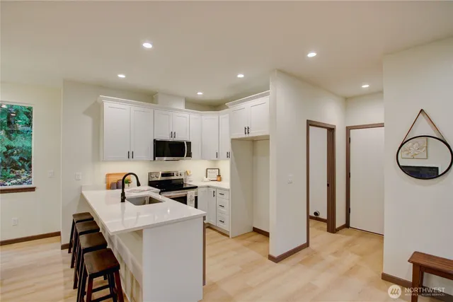 a kitchen with stainless steel appliances a stove a sink a microwave and cabinets