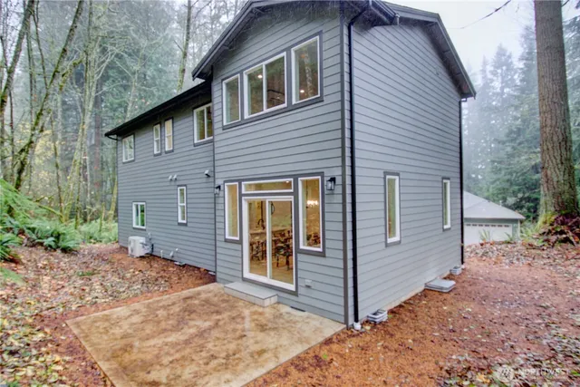 a view of a dining room with furniture a chandelier and large windows