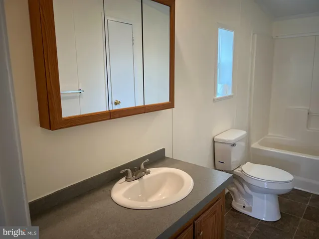 a bathroom with a sink toilet and a mirror