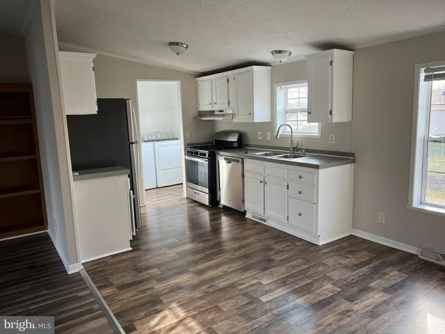 a kitchen with granite countertop a refrigerator stove and sink