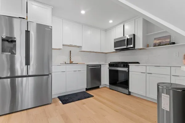 a kitchen with stainless steel appliances a refrigerator sink and microwave