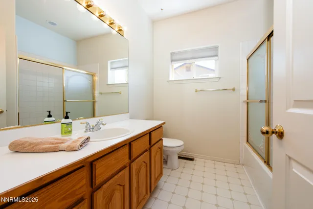 a bathroom with a sink a toilet a mirror and shower