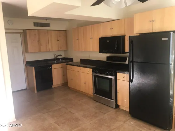 a kitchen with stainless steel appliances granite countertop a stove a sink and a refrigerator