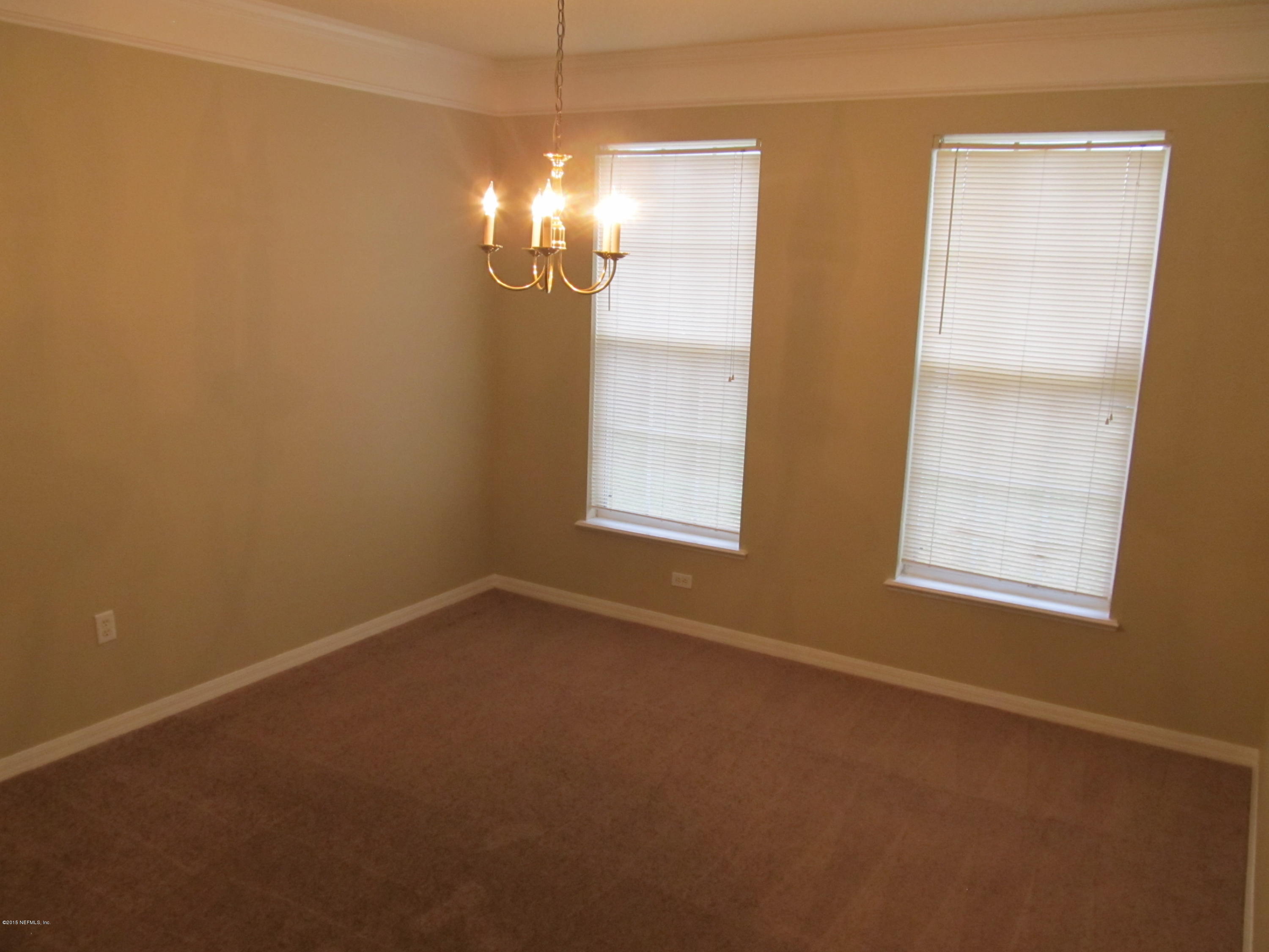 7079 Prosperity Park Road East Jacksonville, FL 32244 - Photo 8 of 22 en empty room with windows and chandelier