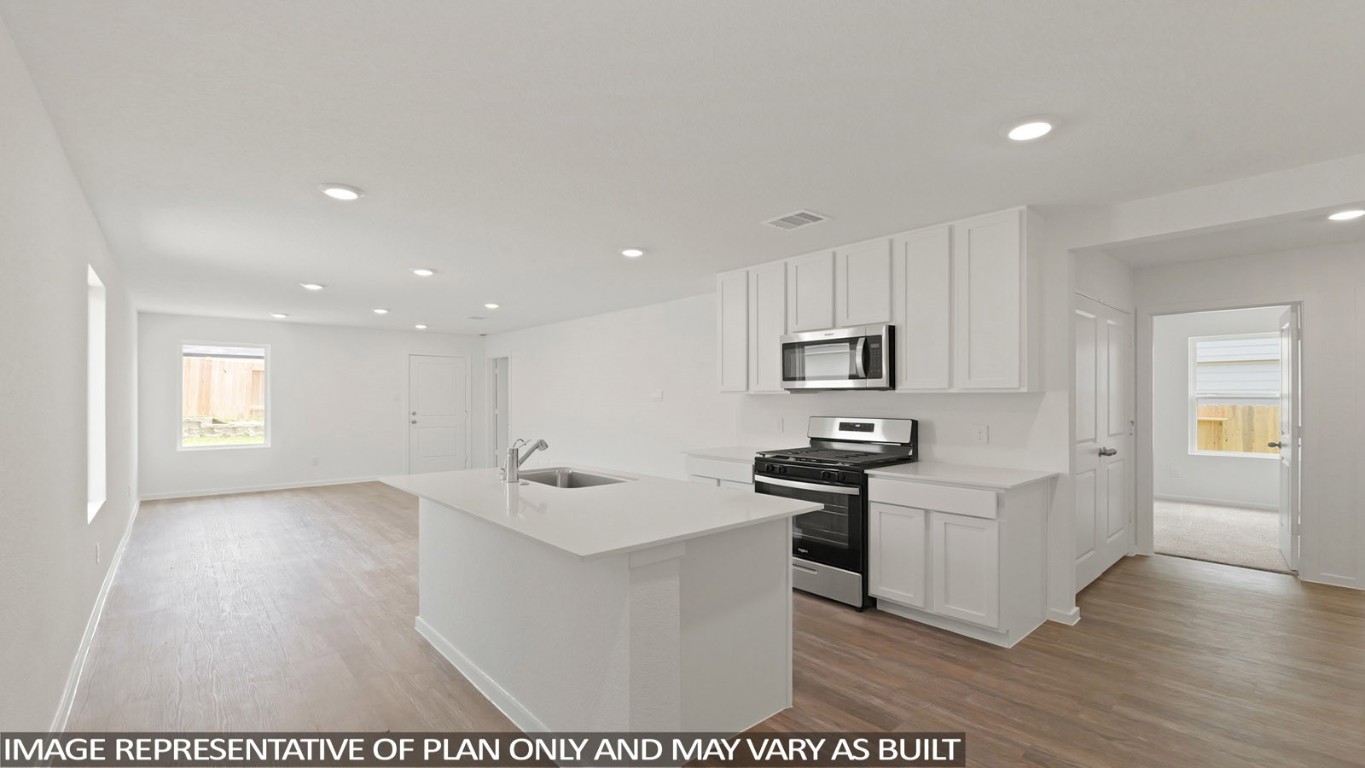 19956 Hilbert Road New Caney, TX 77357 - Photo 3 of 27 a kitchen with stainless steel appliances granite countertop a sink stove and refrigerator