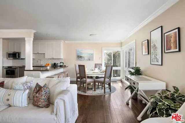 a living room with furniture wooden floor and a view of kitchen
