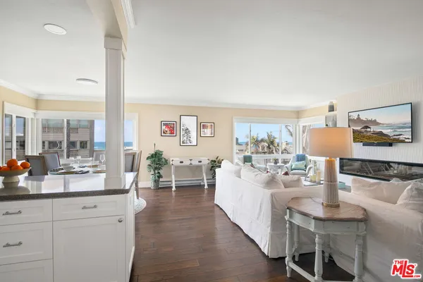 a very nice looking living room with a large window and dining table