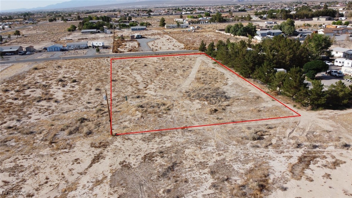 4601 McGraw Road Pahrump, NV 89061 - Photo 3 of 8 Aerial view of residential area featuring a mountainous background, property parcel outlined, and a desert landscape
