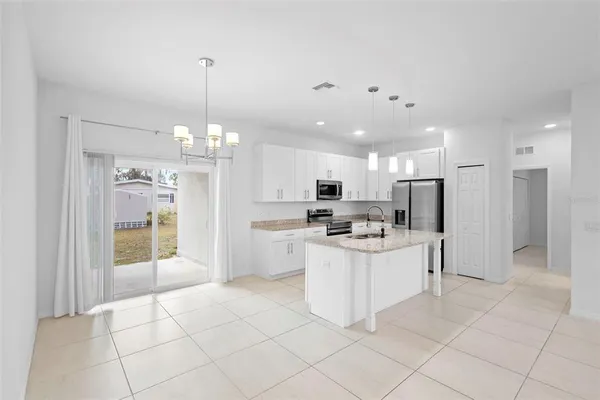 a kitchen with a sink a counter top space stainless steel appliances cabinets and a window