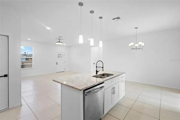 a kitchen with a sink a counter space and a chandelier