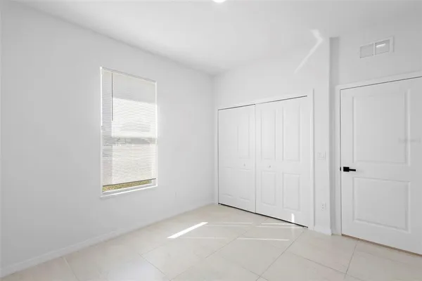 an empty room with white walls and windows