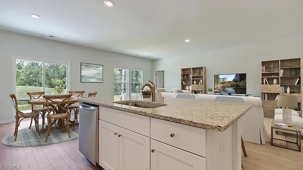 a dining hall with stainless steel appliances granite countertop a table and chairs