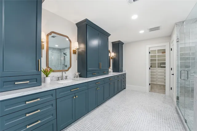 a spacious bathroom with double vanity and a mirror
