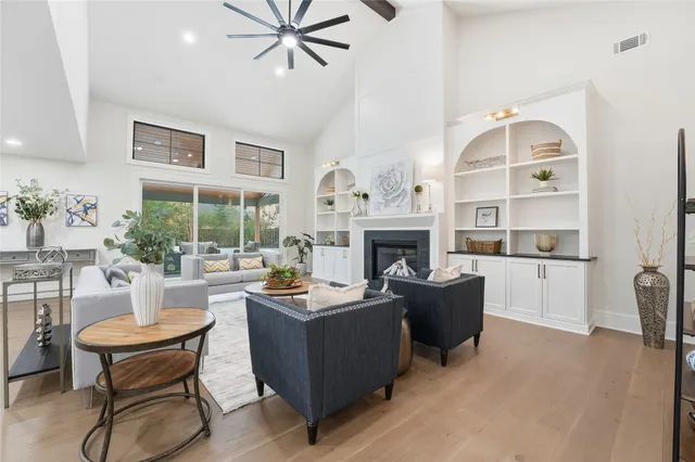 a living room with furniture a fireplace and a chandelier